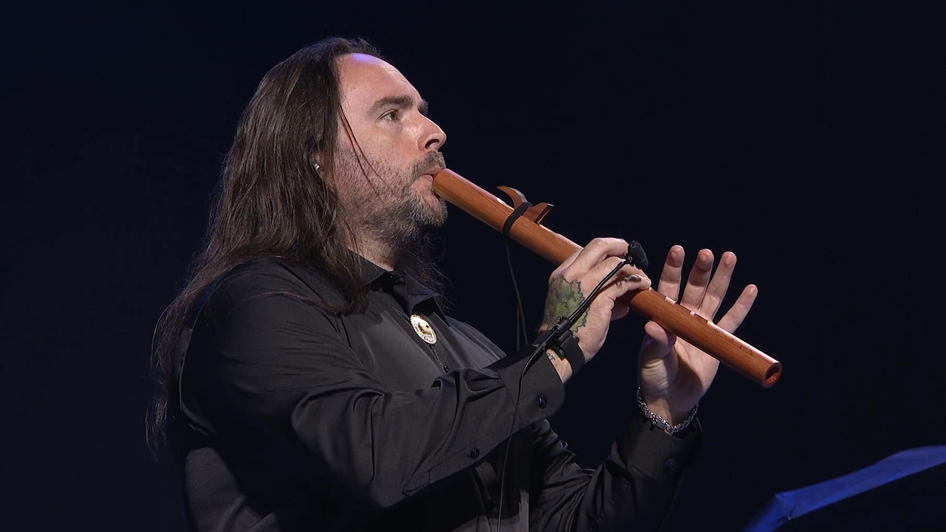 Associate Amagasga Good plays his Native American flute on stage at the 2024 Walmart Associates Week.