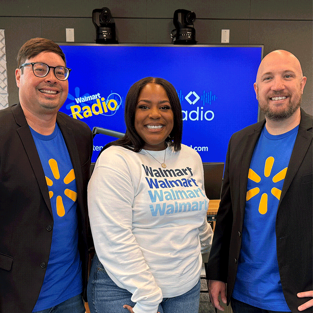 On-air personalities Chris, Kirby and Bo pose in front of a Walmart & Sam's Club Radio banner