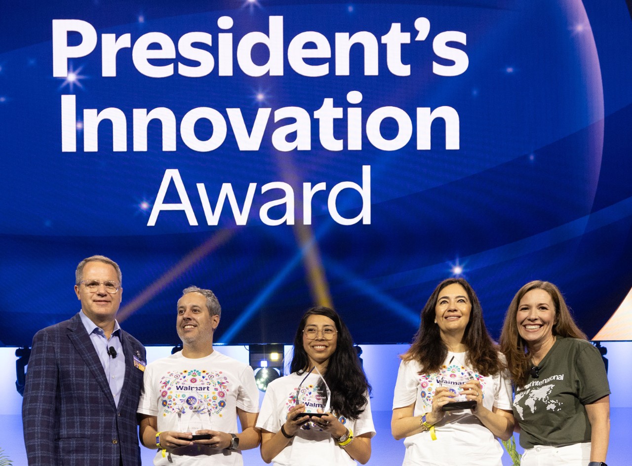 Doug and Kath stand on either side of the President’s Innovation Award winners, the Beneficios Program team from Walmex.